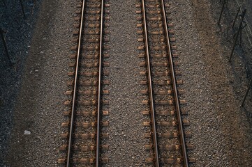 Fototapeta premium Overhead view of dual railroad lines running side by side with freight train, industrial travel scene