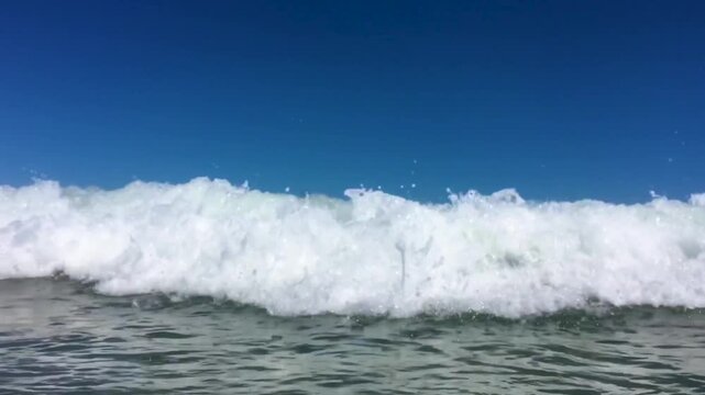 Eye level close up view of an ocean wave rolling toward you in slow motion with no sound and no people. Low point view of an ocean wave