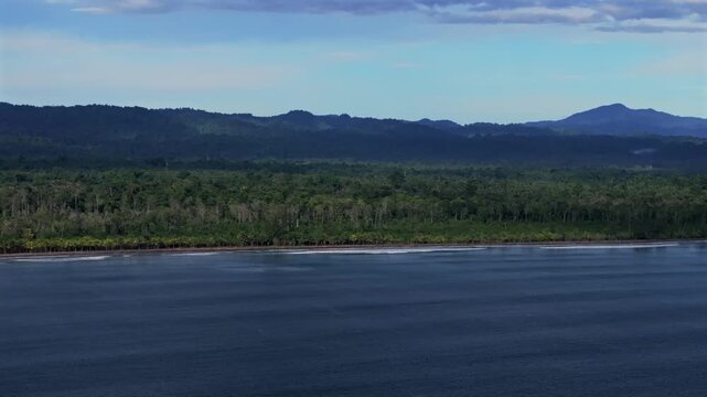 Untouched remote pristine coastline waves Cape Wom Dogreto Bay Harbor View Papua New Guinea PNG aerial drone Madang Wewak Kavieng Vanimo Tufi sunny blue sky tropical beach shoreline forward motion