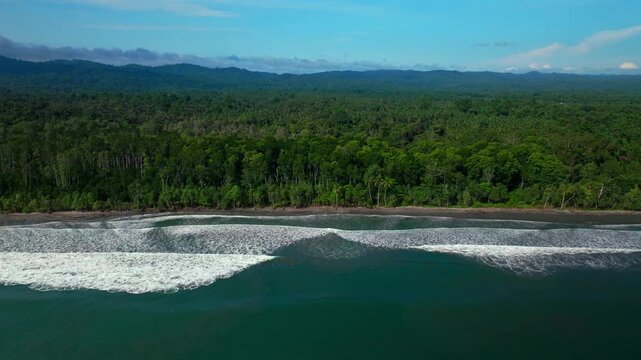 Sunny untouched remote pristine coastline waves Cape Wom Papua New Guinea PNG aerial drone Madang Wewak Kavieng Vanimo Tufi beach blue sky tranquil tropical shoreline East Sepik Province right motion