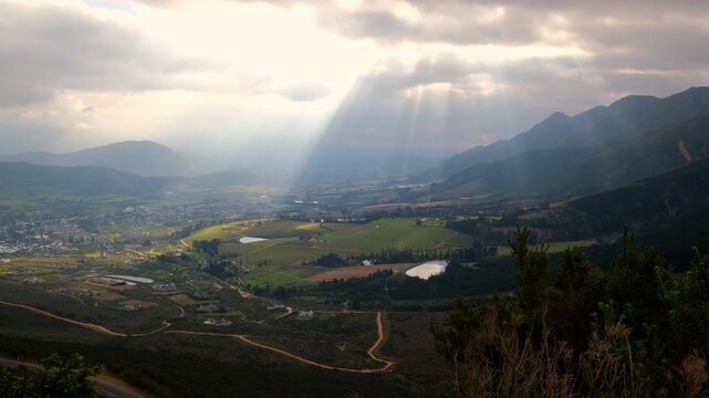 Ethereal god rays fall over Franschhoek valley in Cape winelands, lookout view