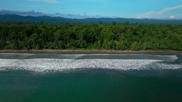 Sunny untouched remote pristine coastline waves Cape Wom Papua New Guinea PNG aerial drone Madang Wewak Kavieng Vanimo Tufi beach blue sky tranquil tropical shoreline East Sepik Province upwards