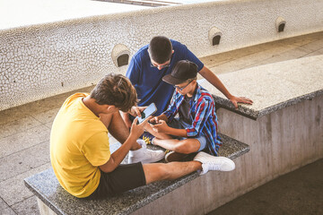 Teenagers friends using smartphone together. Smiling teens browsing social media online. Boys...
