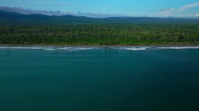 Untouched remote pristine coastline waves Cape Wom Dogreto Bay Harbor View Papua New Guinea PNG aerial drone Madang Wewak Kavieng Vanimo Tufi sunny blue sky tropical beach shoreline forward pan up
