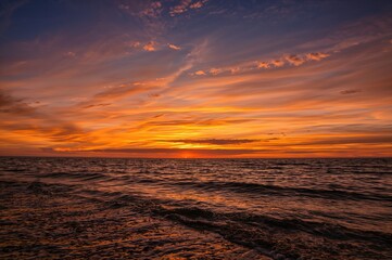 Fototapeta premium As daylight fades, golden and red tones light up the sky, painting a stunning sunset that celebrates the splendor of the natural world.