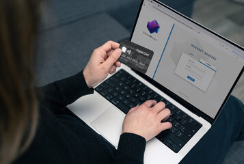 Woman uses digital card for secure online banking.  Modern financial technology, emphasizing ease...