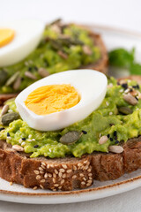 Avocado toast with boiled egg, sunflower seed, pumpkin seed and sesame seed on plate, Healthy eating	