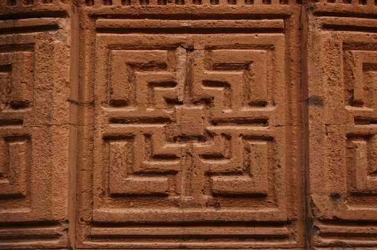 Intricate geometric designs etched into a sandstone surface in a close-up view
