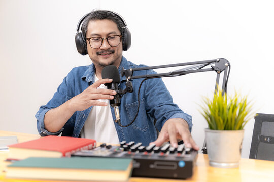 Close-up of young man recording podcast with microphone and headphones in studio. Concept of digital media, online communication, and modern content creation