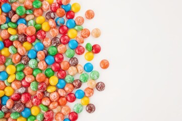 Obraz premium Assorted colorful sweets arranged neatly on a white surface with empty space for text, highlighting unhealthy eating habits.