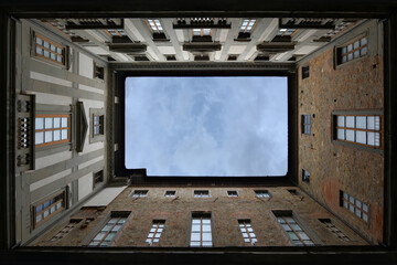 inner space of a building in Florence looking up at the sky, framed by the patio walls 