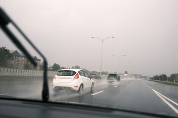 Voiture roulant sur une route mouillée sous la pluie. Flou de mouvement.	