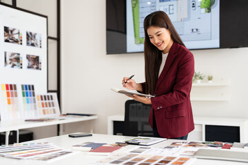 Smiling asian woman, Cheerful young female interior designer or architect in formal wear holding...