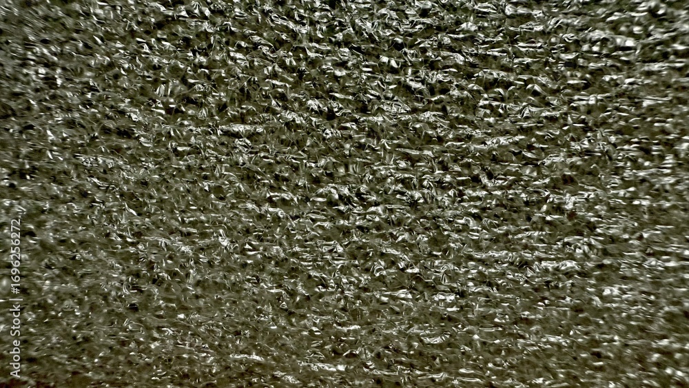 Poster metallic silver crumpled foil texture with reflective creases and intricate folds in macro close up 