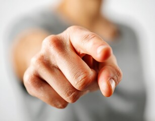 Hand pointing directly forward, with soft focus body and background
