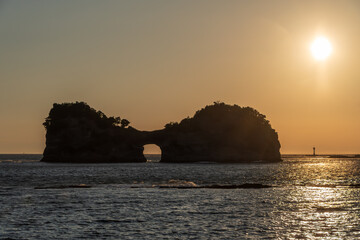 夕日に照らされる円月島のシルエット