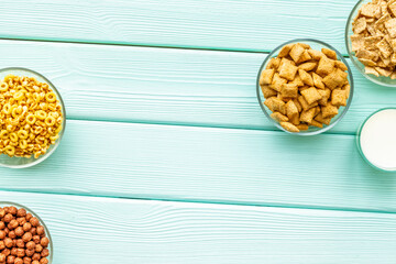 Cereals and flakes from corn and oat on mint wooden background top view mockup