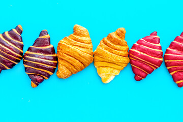 Set of croissants - chocolate, berry, classic - on blue table top view
