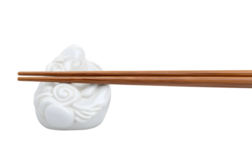 wooden chopsticks resting on a chopstick rest  isolated on white background