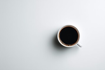 Aerial view of a mug of dark coffee with a white background and space to the left for adding more elements