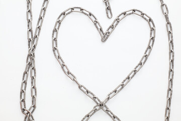 A metallic chain with a shiny, industrial finish, coiled and displayed against a clean white...