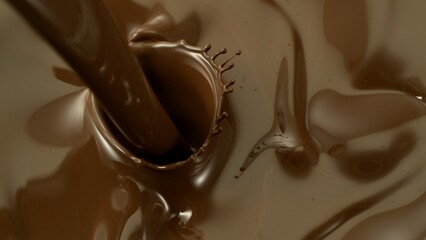Macro shot of premium dark chocolate pouring. Freeze motion, splashing melted chocolate background.