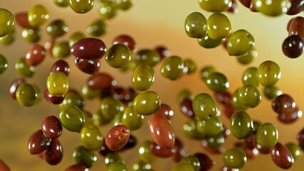 Freeze motion of flying fresh olives, isolated on gradient background.