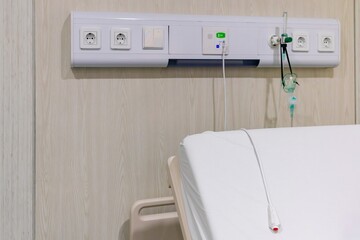 A hospital bed equipped with wall panel integrated with nurse call button system, medical oxygen...