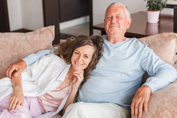 Older mature father and grown millennial daughter laughing embracing, caring smiling young woman embracing happy senior middle aged dad