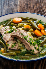 Green bean soup with pork ribs on wooden table	