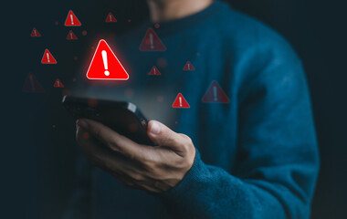 Man holding smartphone with warning alert icon, symbolizing cyber security threat, mobile malware,...