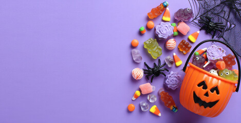 halloween candy and toys on a purple background, a halloween concept, top view
