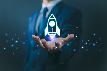 Businessman holding digital rocket icon, symbolizing startup launch, innovation, business growth,...