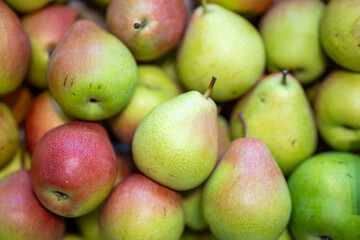 Background of ripe pears lying on a wooden surface.