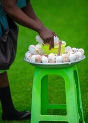  A woman Person selling boiled chicken eggs served with grounded blended hot pepper sauce. a beloved Ghanaian street food snack enjoyed by people of all ages