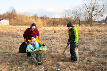 Joyful moments in nature as children play in a wheelbarrow while adults engage in gardening...