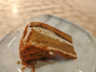 A delicious slice of mocha cake on a plate in a wooden table