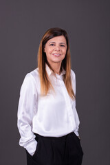 Elegant senior businesswoman smiling with her hands in her pockets