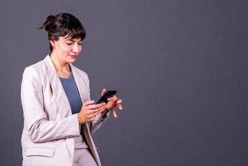 Professional woman with her phone on a gray background