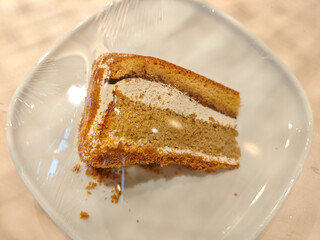 A delicious slice of mocha cake on a plate in a wooden table