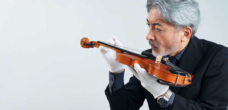 A middle-aged man checking a violin - Powered by Adobe