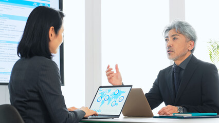 会議、ミーティング、ビジネス、会議室、コピースペース、企業、モニター、提案、相談、日本人、経営、女性、男性、仕事、職場、オフィス、打ち合わせ、ブリーフィング、人材、ミドルエイジ、シニア、中年、社長、経営者、大画面、スライド、プレゼンテーション、営業、カウンセラー、アドバイザー、コンサルタント、面談、カウンセリング、会話、コミュニケーション、計画、企画、プロジェクト、説明、報告、資料、データ、コンサ