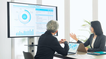 A group of business people meeting in front of a large screen monitor