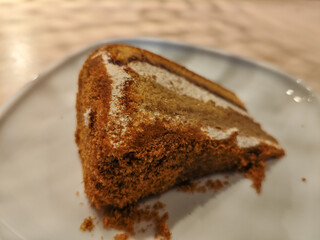 A delicious slice of mocha cake on a plate in a wooden table