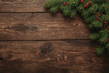Festive backdrop featuring pine branches and ornaments on a rustic dark wood surface