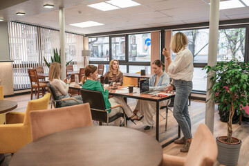 Workplace Team Meeting: Women collaborating in modern office space during daytime for project planning.