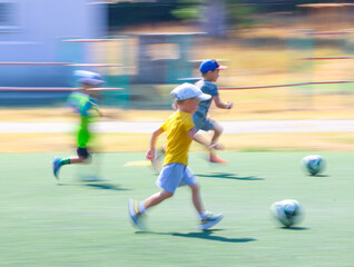 little  boys plays football at a sports school .Blur.