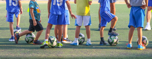 Large group of little boys in sports uniform with soccer balls during training in children's soccer...