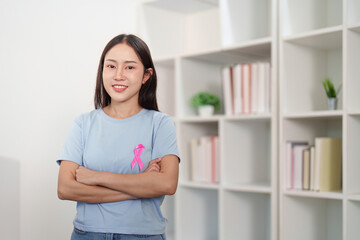Breast Cancer Awareness. Young woman confidently posing with pink ribbon.