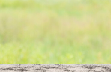Empty rustic concrete table and defocused green grass in the background